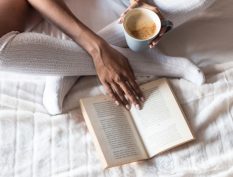 Reading in bed with a cup of coffee