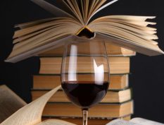 Glass of red wine with books