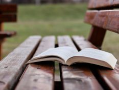Open book on a rainy park bench
